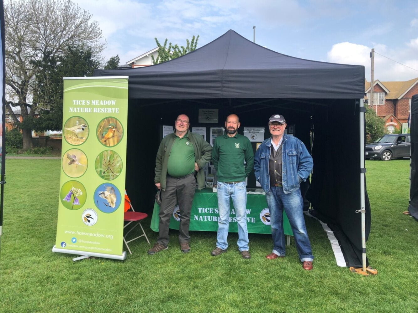 Three males standing inside a small marquee.