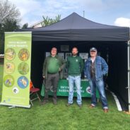 Three males standing inside a small marquee.