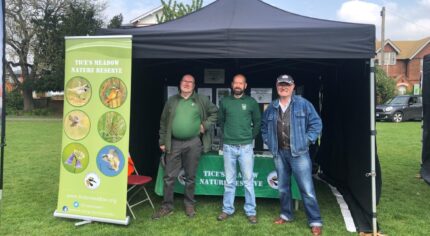 Three males standing inside a small marquee.