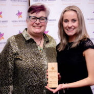 Two females. One holding a trophy.