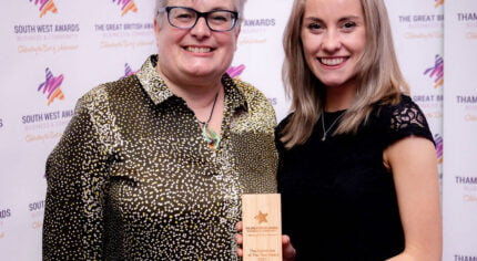 Two females. One holding a trophy.