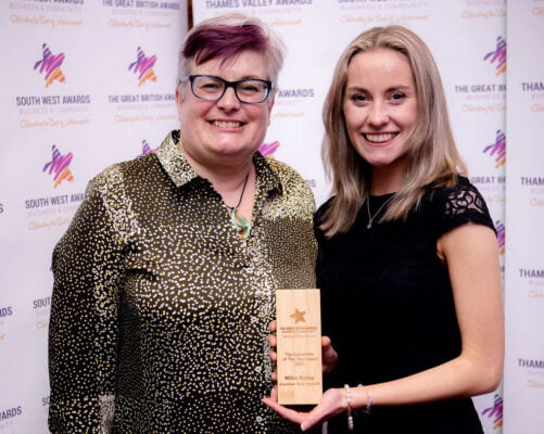 Two females. One holding a trophy.