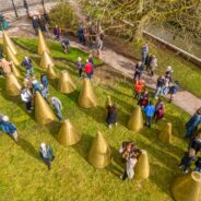 Aerial view of people milling amongst an art installation made up of a series of cones.