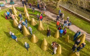 Aerial view of people milling amongst an art installation made up of a series of cones.