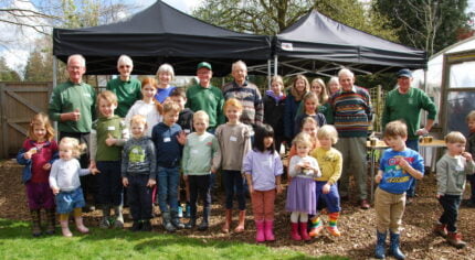 Group of children and adults in outside space.