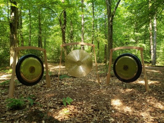 A photo of three large gongs assembled in a wood