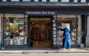 Two females walking past a shop.