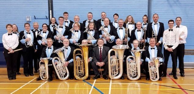 A group photo featuring the band members of the Alder Valley Brass band with their instruments