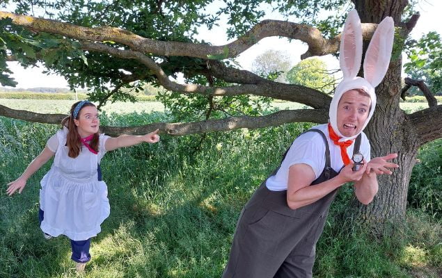 A photo depicting a scene from a live action Alice in Wonderland, of Alice chasing the rabbit.