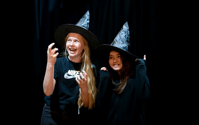 Two smiling young girls dressed in witch fancy dress clothing