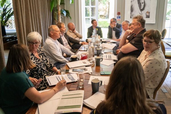 Group of people sitting around a table having a meeting.