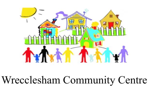 Wrecclesham Community Centre logo consisting of hand drawn houses behind a white picket fence and the silhouettes of lots of people and children holding hands in a row