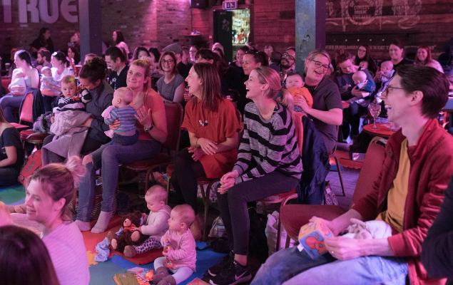 Group of adults and babies laughing.