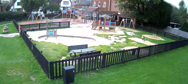 Playground with a fence around it.