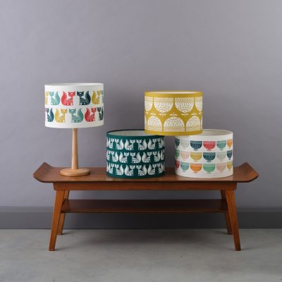 Four lampshades on a coffee table.