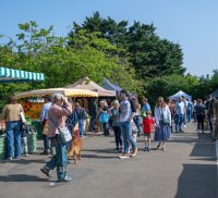 People browsing stalls at a farmers' market.