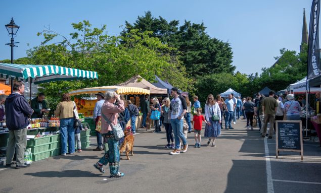 People browsing stalls at a farmers' market.