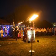 Lighting of a beacon with people in the background.