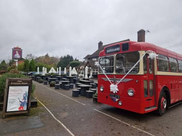 Red bus with a white ribbon attached to the front.