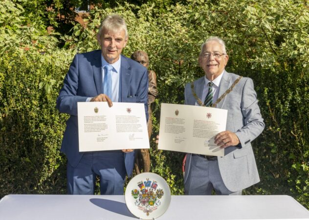 Two men each holding a document.