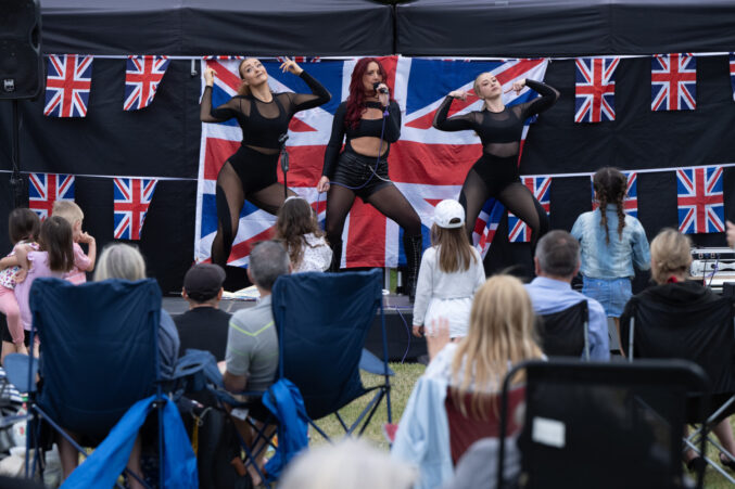 Crowd watching three dancers on a stage.