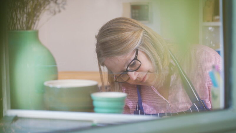 Female looking down. Pots in foreground