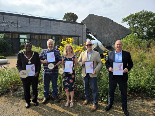 Five people holding certificates