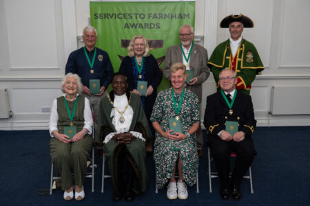 Seven people sitting alongside the Mayor and Town Crier.