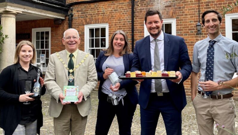 Five people holding food and alcohol.