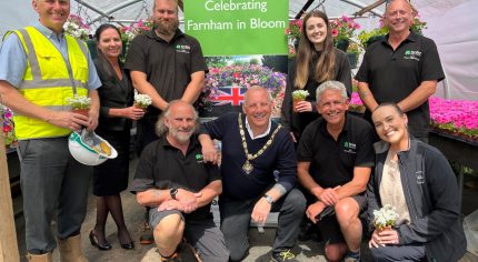 Group of people in a greenhouse celebrating Farnham in Bloom.