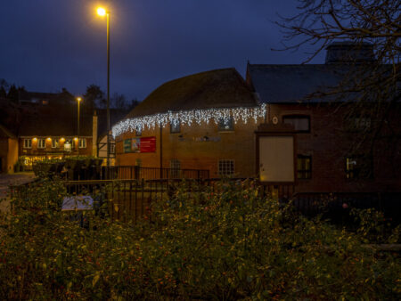 A photo of a building decorated with white Christmas lights