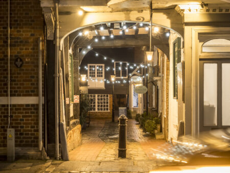 A cobbled alleyway with hanging Christmas lights
