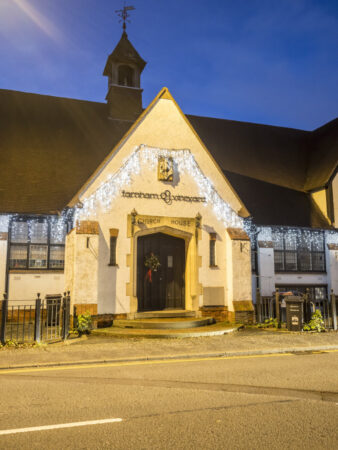 An old building decorated with white Christmas lights