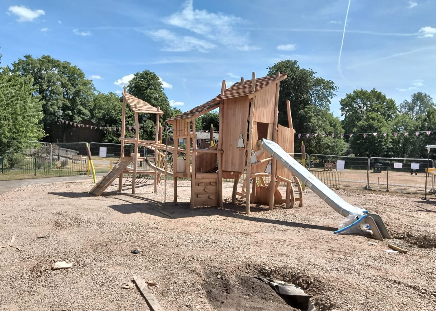 Wooden climbing frame and slide under construction.